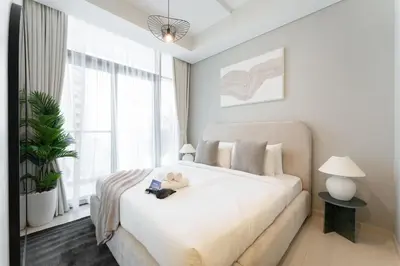 a bedroom with a white bed with a teddy bear on it at StayShort - Inviting 2BR in Business Bay with Wonderful Views in Dubai