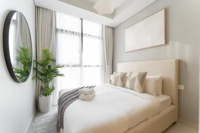 a white bedroom with a large bed and a mirror at StayShort - Inviting 2BR in Business Bay with Wonderful Views in Dubai