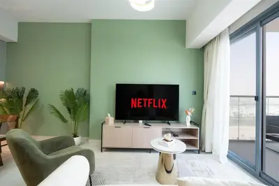 a living room with a television on a cabinet at KeyRock Living - Luxury Apartment with Pool & Gym in Dubai