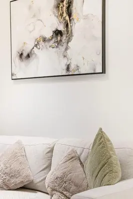 a painting hanging above a couch in a living room at FiveX Binghatti 2BR with Private Pool in Dubai