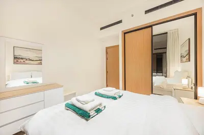 a bedroom with a large white bed and a mirror at FiveX Binghatti 2BR with Private Pool in Dubai