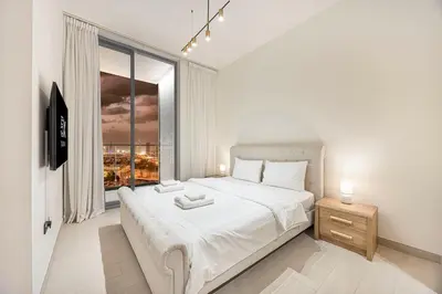a bedroom with a large white bed and a window at FiveX Binghatti 2BR with Private Pool in Dubai