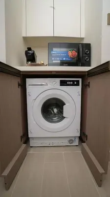 a washing machine with a tv on top of it at NEW Studio in JVC with Pool View in Dubai