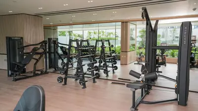 a gym with several treadmills and elliptical machines at NEW Studio in JVC with Pool View in Dubai