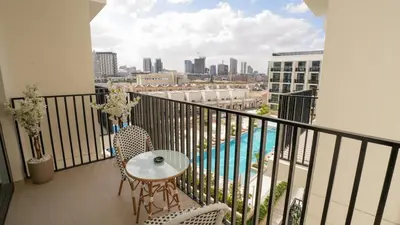 a balcony with a table and chairs and a view of a city at NEW Studio in JVC with Pool View in Dubai