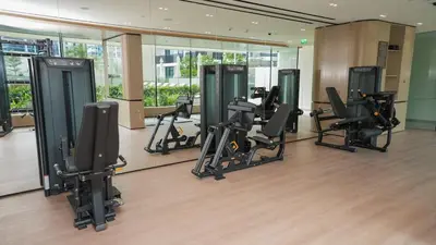 a gym with treadmills and exercise equipment in a building at NEW Studio in JVC with Pool View in Dubai
