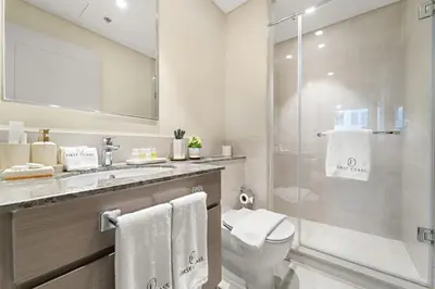a bathroom with a toilet and a glass shower at FIRST CLASS 2BR Stylish Downtown Living in Dubai