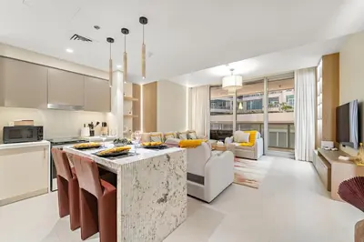 a kitchen and living room with a large island in the middle at FIRST CLASS 2BR Stylish Downtown Living in Dubai