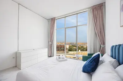 a bedroom with a bed and a large window at FiveX Premium 2BR with Extra Room in Dubai