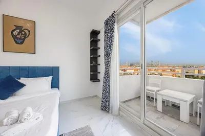 a bedroom with a bed and a large window at FiveX Premium 2BR with Extra Room in Dubai