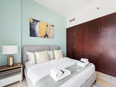 a bedroom with a bed with two towels on it at Prestige Urban Escape 2BDR In La Fontana in Dubai