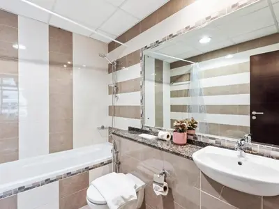 a bathroom with a sink and a toilet and a mirror at Prestige Urban Escape 2BDR In La Fontana in Dubai