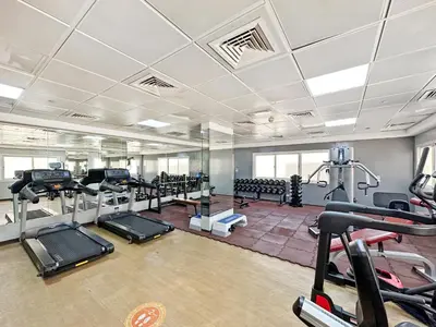 a gym with treadmills and machines in a room at Prestige Urban Escape 2BDR In La Fontana in Dubai