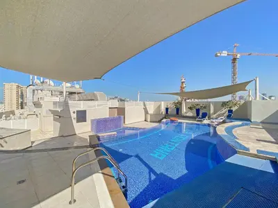 a swimming pool on the roof of a building at Prestige Urban Escape 2BDR In La Fontana in Dubai