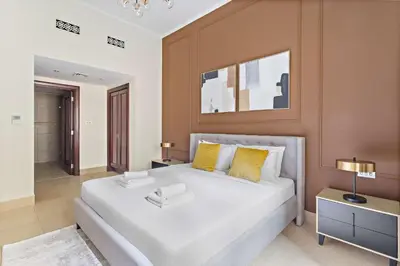 a bedroom with a large white bed with yellow pillows at Silkhaus Private Garden in Old Town Zanzebeel Bldg in Dubai