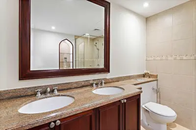a bathroom with two sinks and a toilet and a mirror at Silkhaus Private Garden in Old Town Zanzebeel Bldg in Dubai
