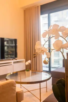 a living room with a coffee table and a flower at Spacious Comfortable One Bed Downtown Dubai in Dubai