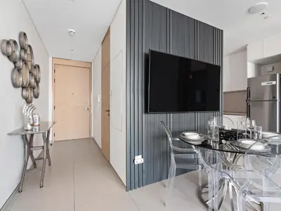 a dining room with a table and a tv on a wall at Timeless Elegance 1BR Address Beach JBR in Dubai