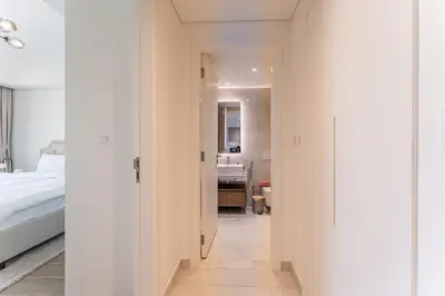 a hallway leading to a bedroom with a bed and a bathroom at HAVN - 1 bedroom in Madinat Jumeirah Living in Dubai