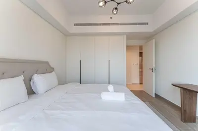 a bedroom with a white bed and a table at HAVN - 1 bedroom in Madinat Jumeirah Living in Dubai