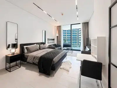 a bedroom with a bed and a living room at Modern Studio with Private Jacuzzi in Dubai