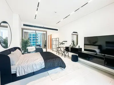 a bedroom with a large bed and a flat screen tv at Modern Studio with Private Jacuzzi in Dubai