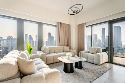 a living room with white furniture and large windows at Rentico l Ultra Luxury 2BR Burj Khalifa & Fountain in Dubai