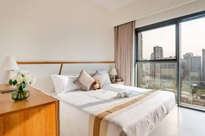 a bedroom with a large bed and a large window at Rentico l Ultra Luxury 2BR Burj Khalifa & Fountain in Dubai
