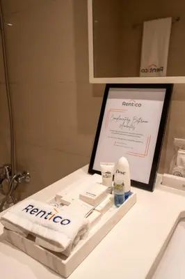 a bathroom counter with a mirror and a sink with towels at Rentico l Ultra Luxury 2BR Burj Khalifa & Fountain in Dubai