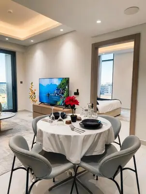 a dining room with a white table and chairs at Jumeirah Village Triangle in Dubai
