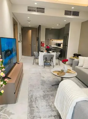 a living room with a couch and a tv at Jumeirah Village Triangle in Dubai