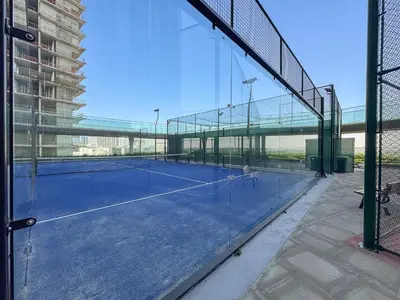 a tennis court with a net in a building at Luxury 1BR - Miracle Garden View - Skyz in Arjan in Dubai