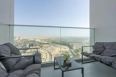 a living room with a view of a city at Luxury 1BR - Miracle Garden View - Skyz in Arjan in Dubai