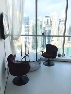 a room with two chairs and a table in front of a window at Full marina view private pool vip adult only no halal in Dubai