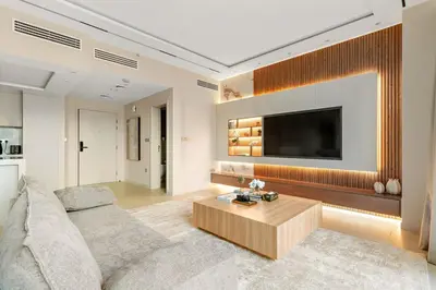 a living room with a couch and a tv at FIRST CLASS 1BR Elegance Near Burj Khalifa in Dubai
