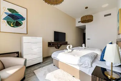 a bedroom with a large bed and a tv at Prestige Avani Residence 2BR with Golf Course View in Dubai