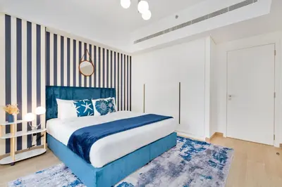 a bedroom with a blue bed and a striped wall at Brand New Luxury Family Friendly 3 beds Near Burj AlArab Ultimate Stay in Dubai