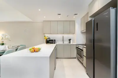 a kitchen with white cabinets and a white counter top at Brand New Luxury Family Friendly 3 beds Near Burj AlArab Ultimate Stay in Dubai