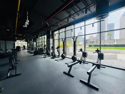 a gym with rows of exercise equipment in a building at Curated High Floor 1BR-Sofa Bed Water View Peninsula 1 in Dubai