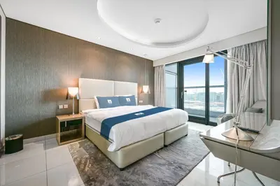 a bedroom with a large bed and a large window at Amazing 1BR DAMAC Towers by Paramount in Dubai