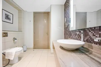 a bathroom with a large white sink and a toilet at Amazing 1BR DAMAC Towers by Paramount in Dubai