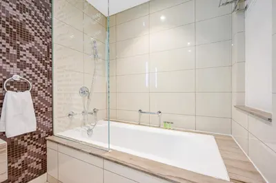 a bathroom with a tub and a glass shower at Amazing 1BR DAMAC Towers by Paramount in Dubai