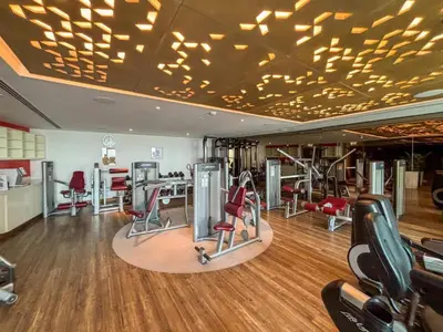 a gym with treadmills and exercise equipment on a wooden floor at Amazing 1BR DAMAC Towers by Paramount in Dubai