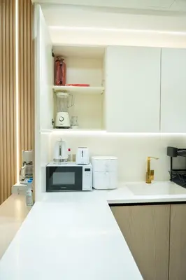 a kitchen with a counter top with a microwave at Binghatti Aurora, JVC Dubai - Unique Round Bed Experience with pool view in Dubai