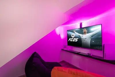 a living room with a tv in a pink room at Luxury Duplex Penthouse with Stunning Marina Views in Dubai
