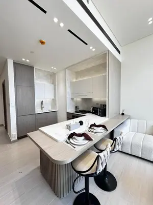 a kitchen with a large island with two bar stools at Modern1BR Binghatti Phantom Private pool JVC in Dubai