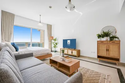 a living room with a couch and a bed at Amazing View Studio Lago Vista IMPZ in Dubai