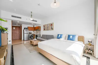 a bedroom with a large bed and a living room at Amazing View Studio Lago Vista IMPZ in Dubai