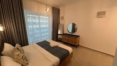 a bedroom with a bed and a window with a mirror at Spacious and Cozy 1BR Opal Tower Stunning Marina View in Dubai