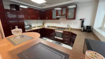 a kitchen with wooden cabinets and a counter top at Spacious and Cozy 1BR Opal Tower Stunning Marina View in Dubai